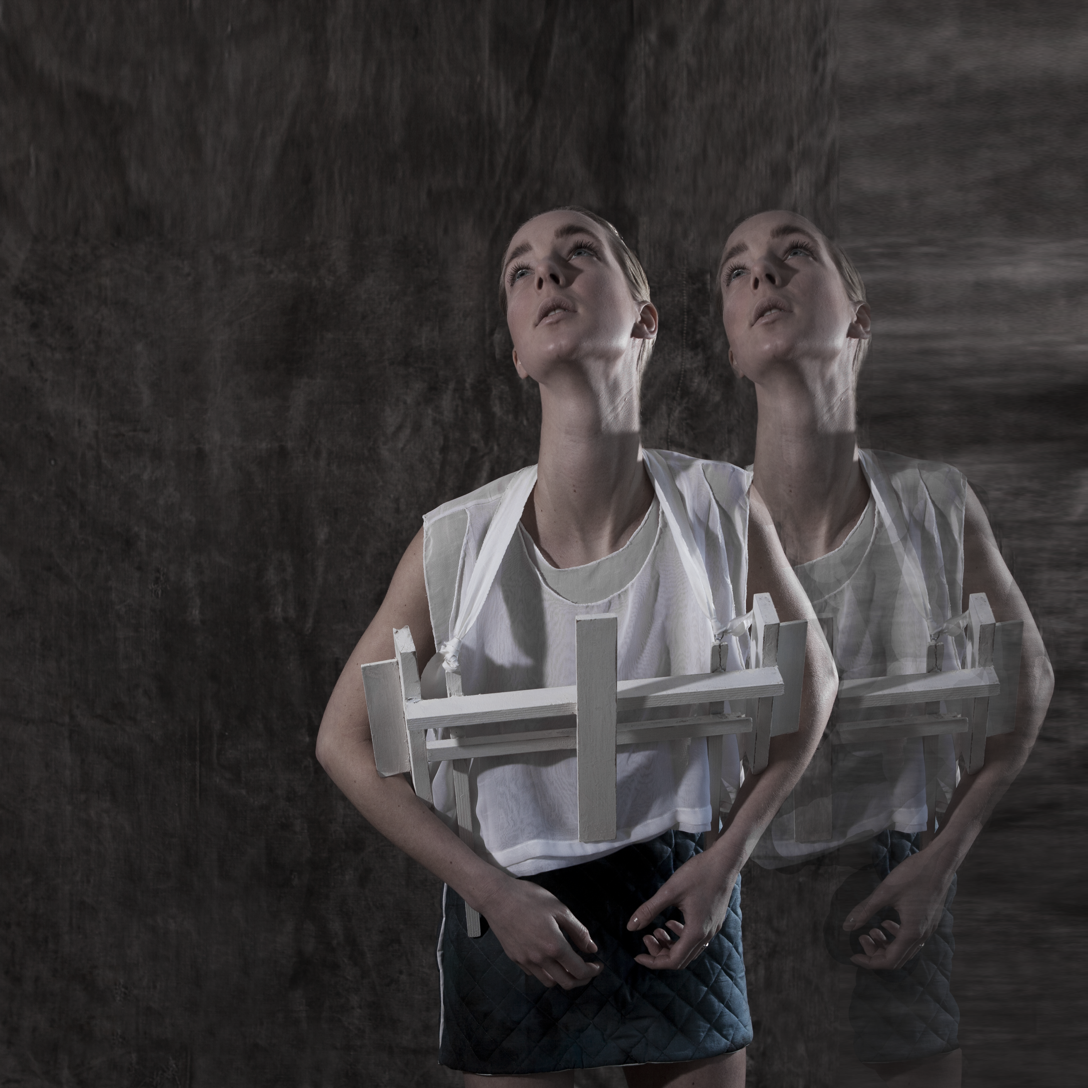 Cross-Bearer — double exposure of figure bearing a white wooden cross construction, gazing upward — Julia Krantz